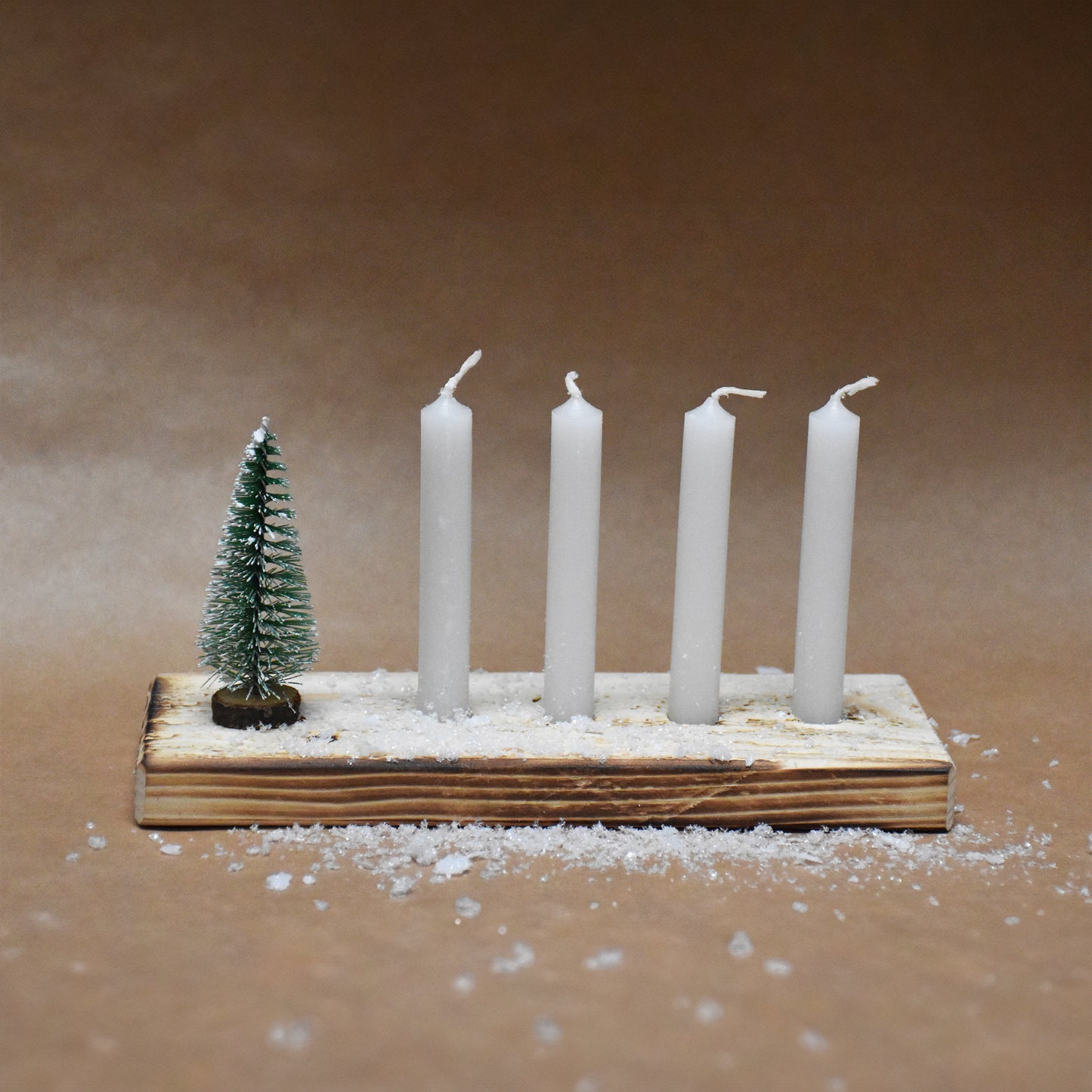 Brett mit vier Kerzen und Tanne
