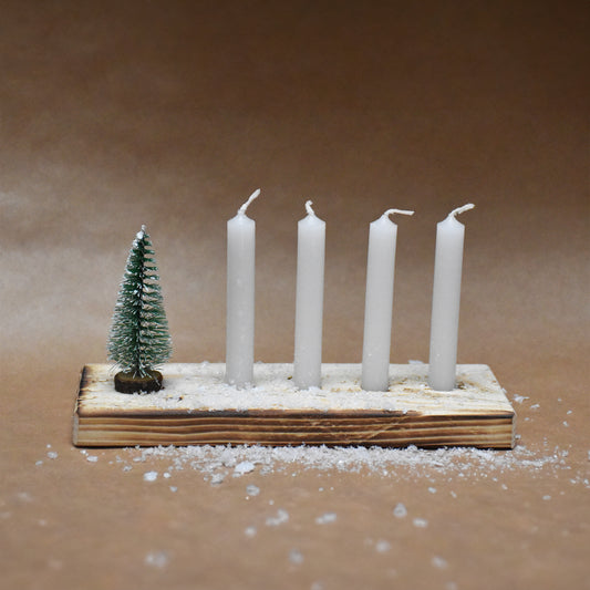 Brett mit vier Kerzen und Tanne