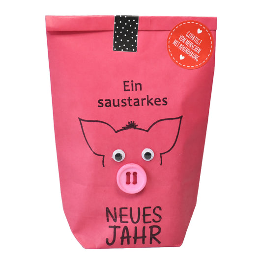 Neujahrsgeschenk Wundertüte in pink bestempelt mit Schweinskopf für ein saustarkes neues jahr